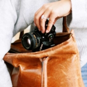woman with camera in leather bag