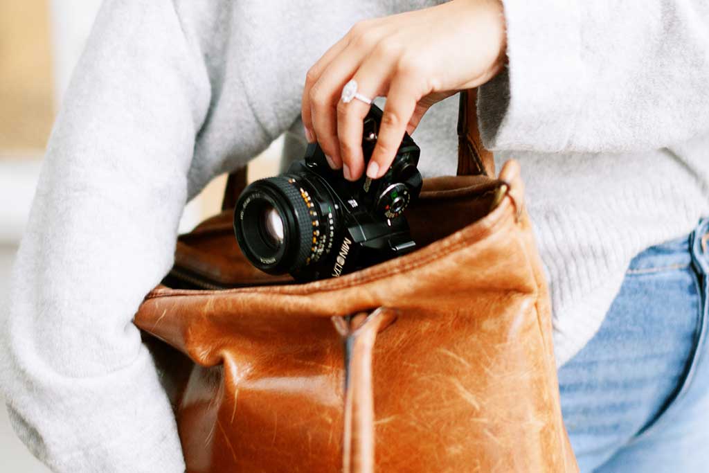 woman with camera in leather bag